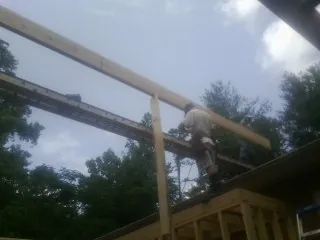 Carpenter setting a ridge beam over a new addition frame — Ice Dam Removal by Roofing Brothers in Dazey