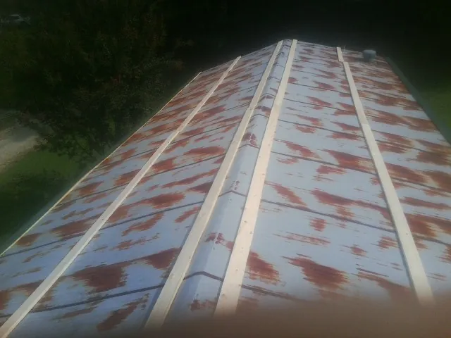 Rusted metal roof panels with new wood purlins before replacement — Storm Damage Roof Repair in Dazey by Roofing Brothers