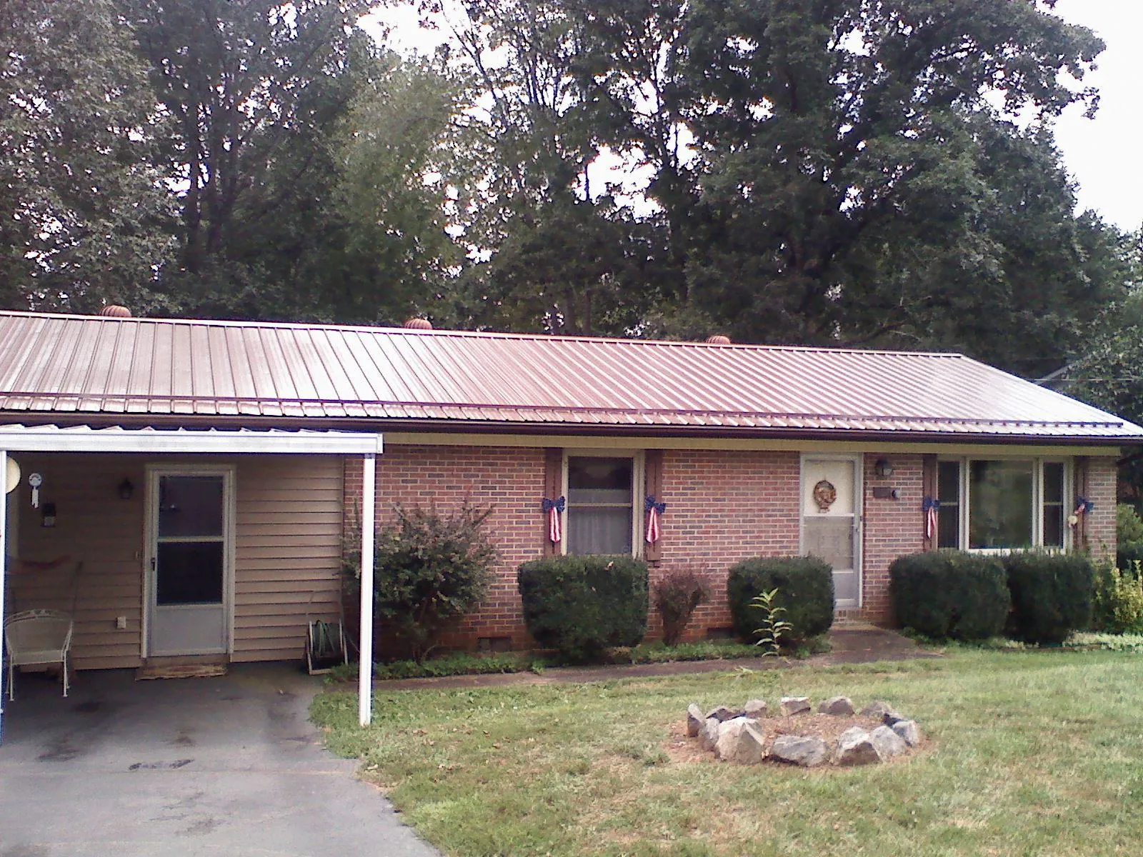 Bronze metal roof and carport on a brick ranch home — Roof Repair work by our crew in Dazey